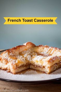 french toast casserole on a plate with powdered sugar over the top and below