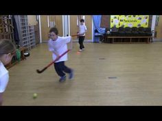 two young boys are playing with tennis balls and rackets in an indoor gym area