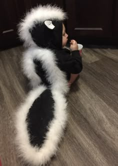 a baby is sitting on the floor with a stuffed animal in it's arms