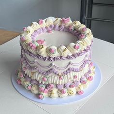 there is a large cake that has been decorated with pink and purple flowers on it