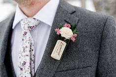 a man wearing a suit and tie with a boutonniere on his lapel