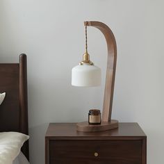 a lamp is on top of a night stand