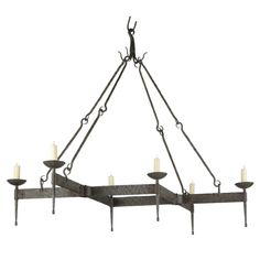 an iron chandelier with six candles hanging from the bottom and four arms on each end