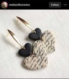 two heart shaped earrings with black and white hearts on them, hanging from gold hooks