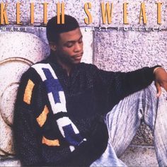 a man sitting on top of a stone bench wearing a sweater and pants with the words keetith sweats