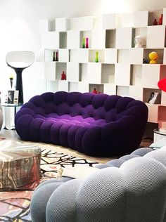 a living room filled with lots of furniture and bookshelves on the wall behind it