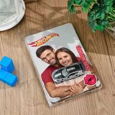 a couple holding each other on top of a wooden table next to blue cubes