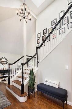 a staircase with pictures on the wall and a bench