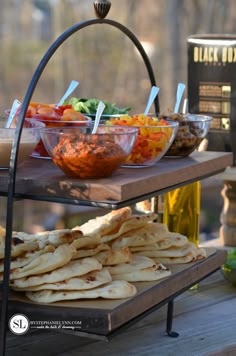 an assortment of food is displayed on three tiered trays