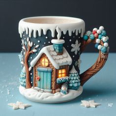 a coffee mug with a house on it and snow falling all over the outside,