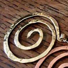 This large spiral pendant is inspired by the graceful spirals of the nautilus. Each spiral is hand-shaped and hammered with the signature texture from my antique anvil. The texture comes from years of history, and every nick, dent and cranny is transferred to the metal by hammer stroke.Great for everyday wear, this spiral pendant hangs from a delicate sterling chain with spring clasp and daisy loop giving it that extra little detail. A perfect gift for you, a friend or a loved one. The size of t Spiral Brass Jewelry, Unique Hammered Spiral Jewelry, Hammered Brass Spiral Jewelry, Spiral Copper Necklace In Gold Color, Gold Spiral Necklace In Copper, Gold Spiral Necklace Nickel Free, Gold Spiral Nickel-free Necklace, Electroformed Spiral Metal Jewelry, Spiral Electroformed Metal Jewelry