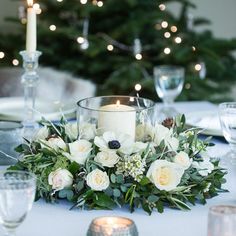 a table topped with white flowers and candles