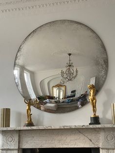 a living room with a fire place and a mirror on the wall above it's mantle