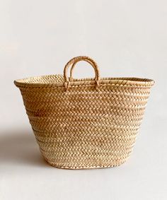 A large woven straw basket called Le Market Basket, featuring two small handles, set against a neutral background. Full Bed Loft, Crib Conversion Kit, Turtle Rock, Peg Rack, Shoe Basket, Kitchen Goods, Market Basket, Crib Toddler Bed, Chair Storage