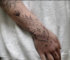 a person with a tattoo on their arm that has flowers and stars all over it