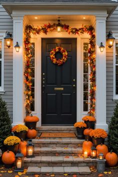 a front door decorated for fall with pumpkins and candles