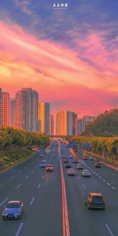 cars are driving down the highway in front of tall buildings at sunset or sunrise time