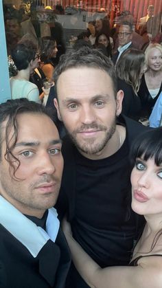 two men and a woman posing for a photo