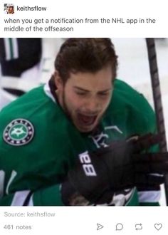 a man in green jersey and black gloves holding a hockey stick with his mouth open