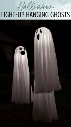 two white ghost statues with the words halloween light - up hanging ghosts