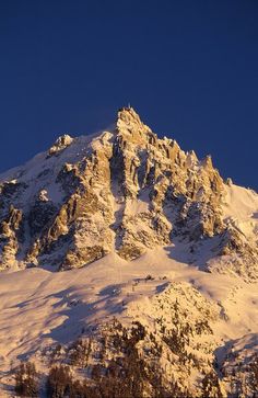 a mountain covered in snow under a blue sky