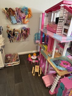 there is a doll house with barbie dolls in it and other toys on the floor