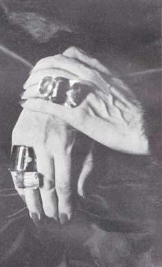 a person's hand with two rings on it and a blanket over their head