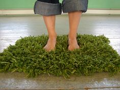 a woman standing on top of a pile of green grass with her feet in the air