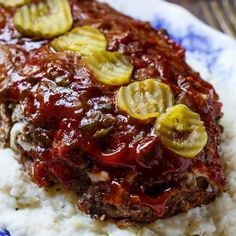 meatloaf and mashed potatoes on a blue and white plate with gravy