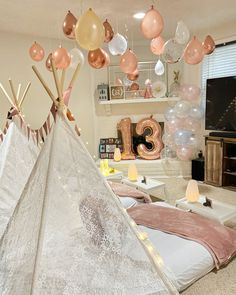 a teepee tent with balloons hanging from the ceiling