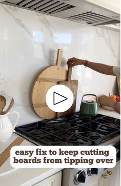 a woman standing in front of a stove top oven next to a wooden spatula