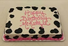 a birthday cake with black and pink frosting