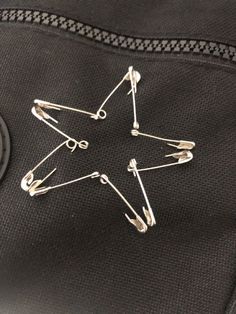 a star shaped pin sitting on top of a black piece of luggage with pins attached to it