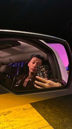 a man taking a selfie in the side mirror of a car