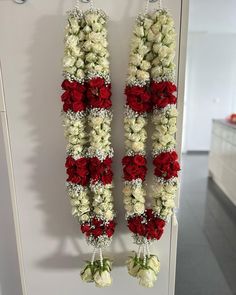 two red and white flowers hanging from hooks on a wall in an office building or conference room