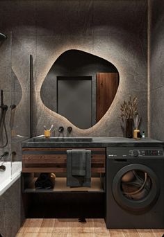 a washer and dryer in a bathroom next to a tub with a mirror on the wall