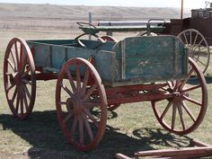 an old fashioned wagon sitting in the grass