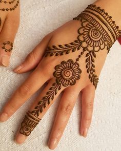 a woman's hand with henna tattoos on it