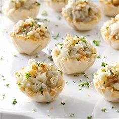 small appetizers are arranged on a white platter