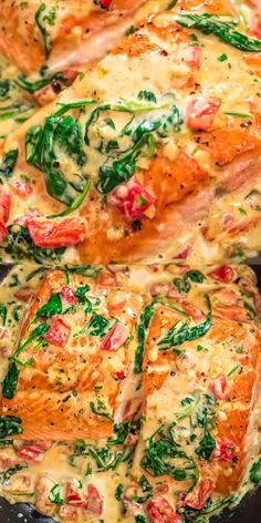 two cooked salmon fillets in a skillet with spinach and cheese on top