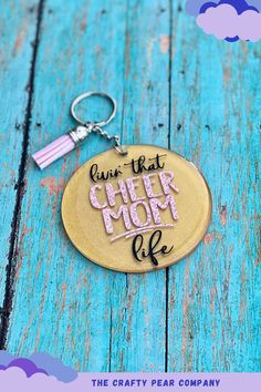 a keychain with the words give that cheer mom life written on it and a tassel