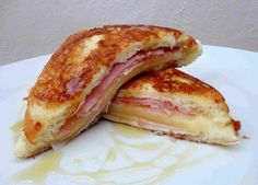 two ham and cheese grilled sandwiches on a white plate