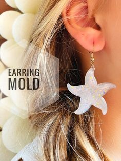 the earring mold is made from white acrylic and has a starfish design on it