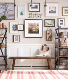 a living room filled with lots of pictures and decor on the wall next to a coffee table