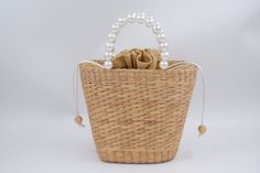 pearl straw bag, woven bag with pearl handle, bridesmaid Gift, bridal party gifts, wedding favour bags, birthday gift Straw Weave Handbag is 100% handcrafted by local Thailand artists, from a water hyacinth. The work is exquisite and of a very high quality. the bags is created with love and hand worked,that makes it unique and one of a kind also a perfect bag or gift for a girl - ++ Detail ++ Approx size : Wide 10 cm (bottom of bag 16 cm) Length 23 cm Height 20 cm Made from : water hyacinth with faux pearl  HOW TO CARE  1. Avoid humidity and expose them to the sun often. 2. Spot clean with damp cloth SHIPPING: # Processtimes 3-5 days # We will be SHIPPED via THAI AIRMAIL and had TRACKING No. # and Delivery Time 1-5 week Contact me if you want large quantity for wholesale Thank You ♥ NORNOR Wedding Favour Bags, Favour Bags, Woven Handbags, Pearl Bag, Water Hyacinth, Favor Bag, Bridal Party Gifts, Gifts Wedding, Woven Bag