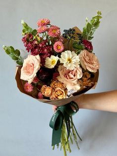 a person holding a bouquet of flowers in their hand