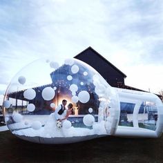 a bride and groom in a bubble filled with white bubbles at their wedding reception venue