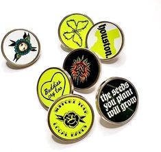 six pinback buttons with different designs on them, all in black and yellow colors