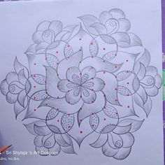 a drawing of a flower with red dots in the center and leaves around it on a sheet of paper