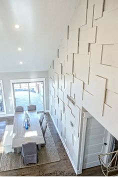 Modern dining area with a large table, grey chairs, unique wall panel design, and glass doors leading to a deck. Wallpaper Living Room Accent Wall, Plywood Wall, Accent Wall Colors, Room Accent Wall, Plywood Walls, Diy Accent Wall